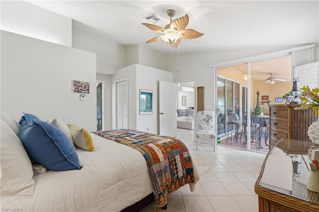 Interior space featuring light tile flooring, a ceiling fan with leaf-shaped blades, and white walls