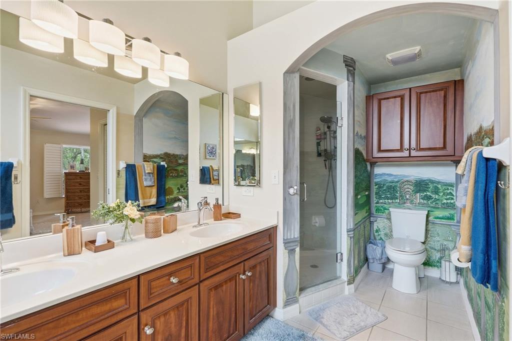 Dual vanity with integrated sinks and white countertops, complemented by wood-finish cabinetry