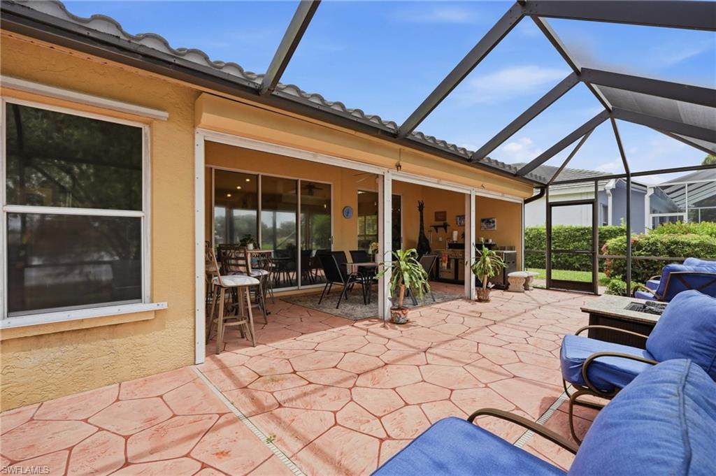 Expansive screened patio featuring textured tile flooring, a covered lanai, and sliding glass doors