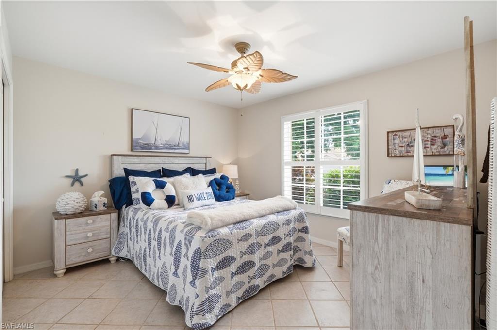 Spacious room featuring neutral wall tones, tile flooring, and a ceiling fan with integrated lighting