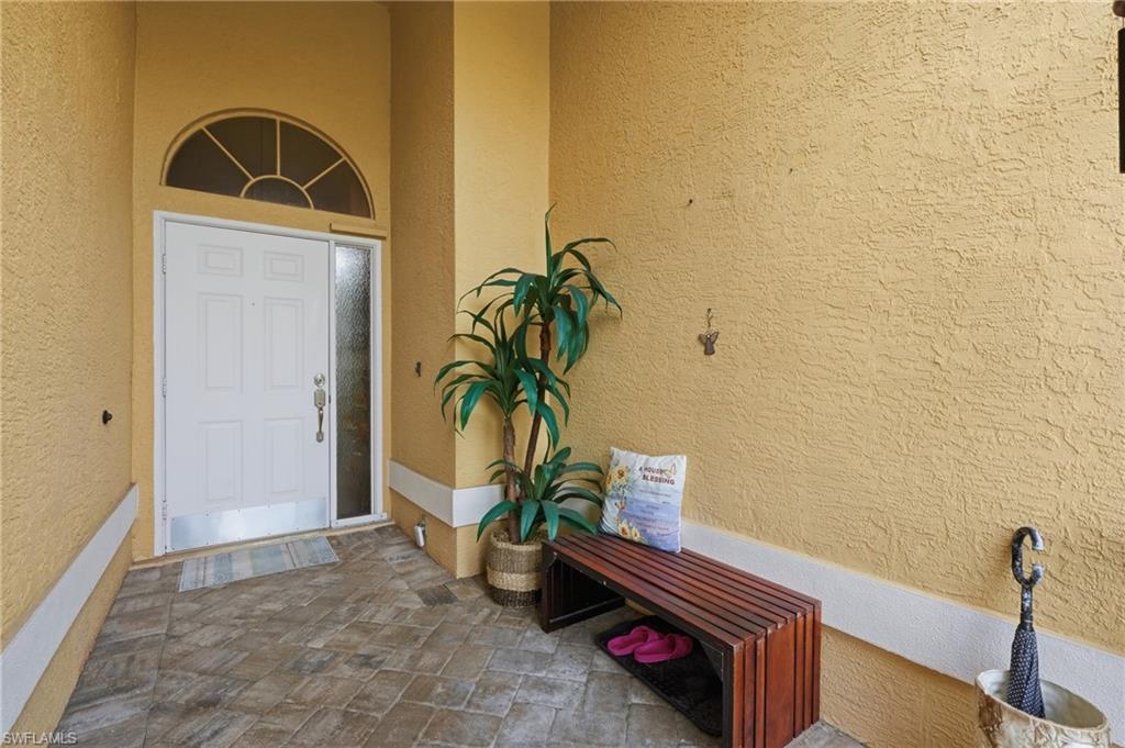 Entryway featuring a paneled white door with an arched transom window and a full-length sidelight