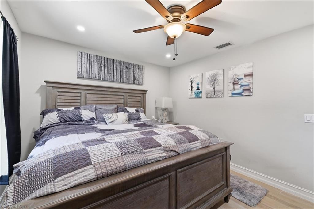 Spacious room featuring light-toned wood-finish flooring, recessed lighting, and a ceiling fan with light fixture