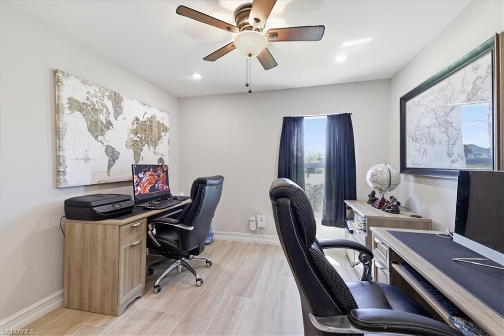Room featuring wood-finish flooring, recessed lighting, and a ceiling fan with light fixture