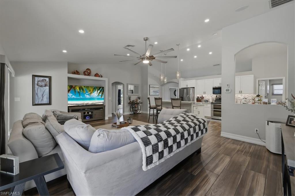 Open-concept living space featuring wood-finish flooring, recessed lighting, and a neutral color palette