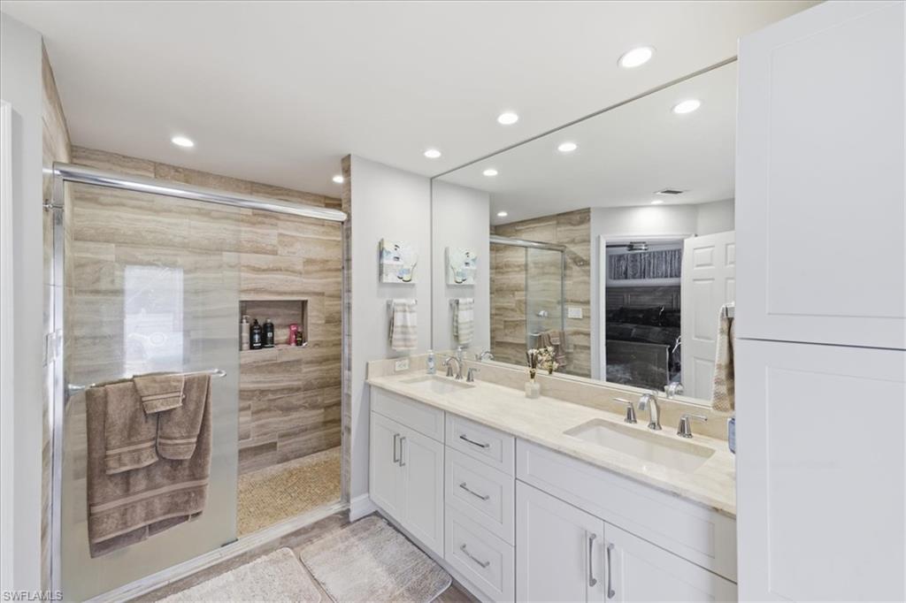 Modern bathroom featuring a double vanity with stone countertop and undermount sinks