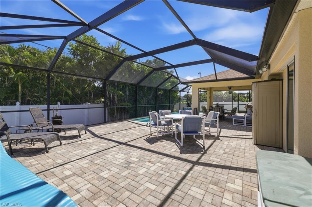 Screened-in outdoor living space featuring a paver patio, integrated swimming pool, and covered lanai with additional seating