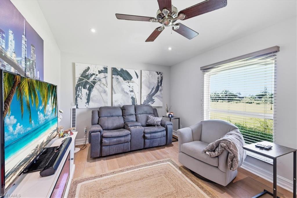 Bright interior room featuring wood-finish flooring and a ceiling fan with integrated lighting