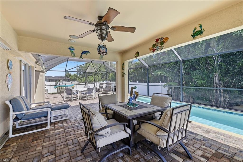 Covered patio featuring a ceiling fan, recessed lighting, and brick-finish flooring