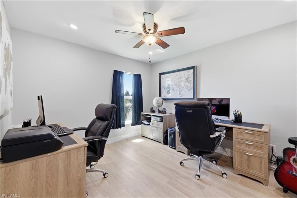 Bright room featuring wood-finish flooring and a ceiling fan with integrated lighting