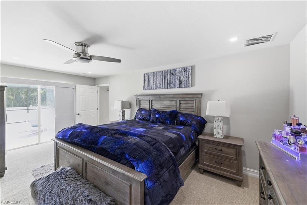 Carpeted bedroom with a sliding glass door providing outdoor access, featuring recessed lighting, a ceiling fan, and a light gray wall color