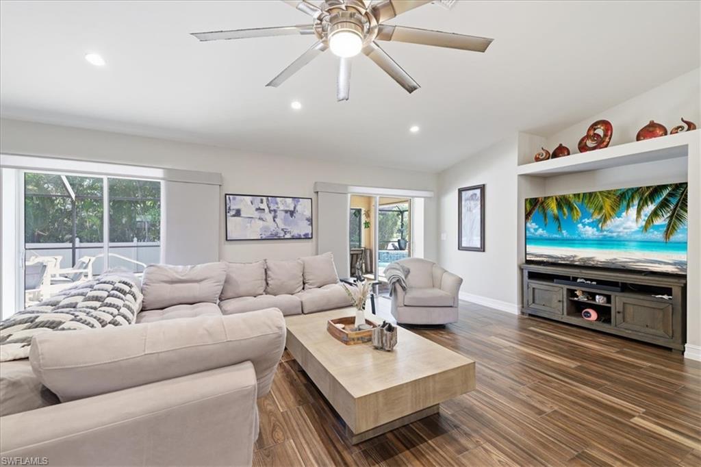 Spacious living area featuring wood-finish flooring, recessed lighting, and a ceiling fan