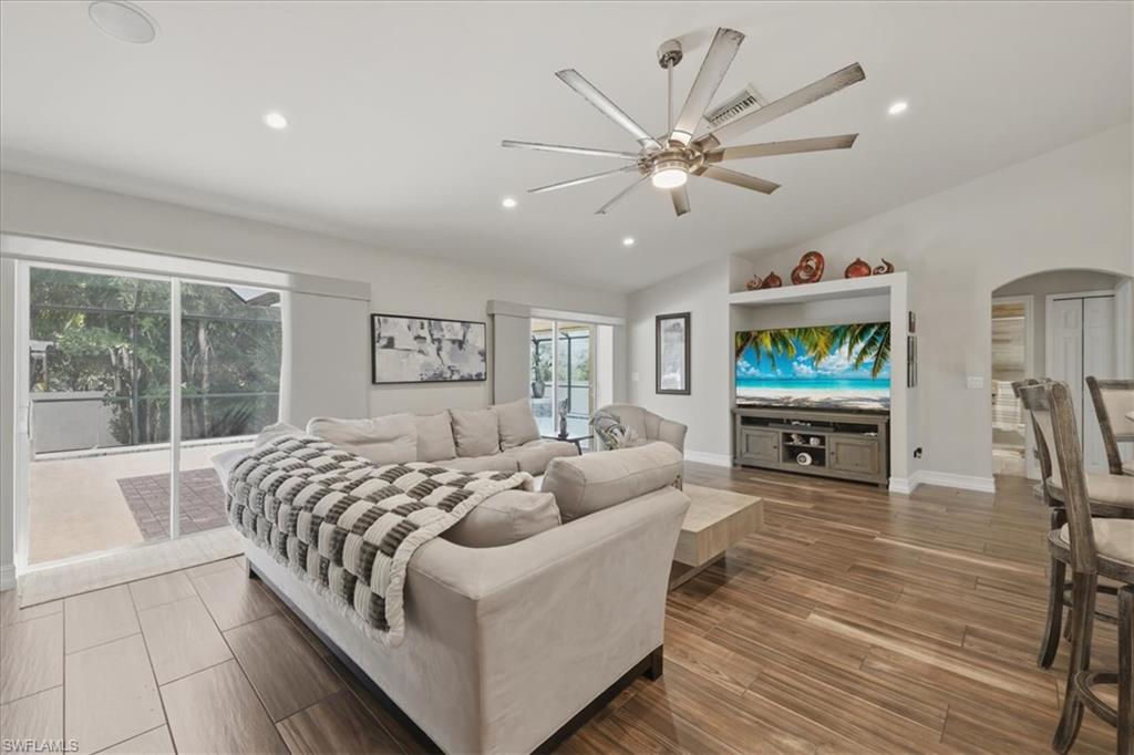 Spacious interior featuring wood-finish flooring, vaulted ceilings, recessed lighting, and a contemporary ceiling fan