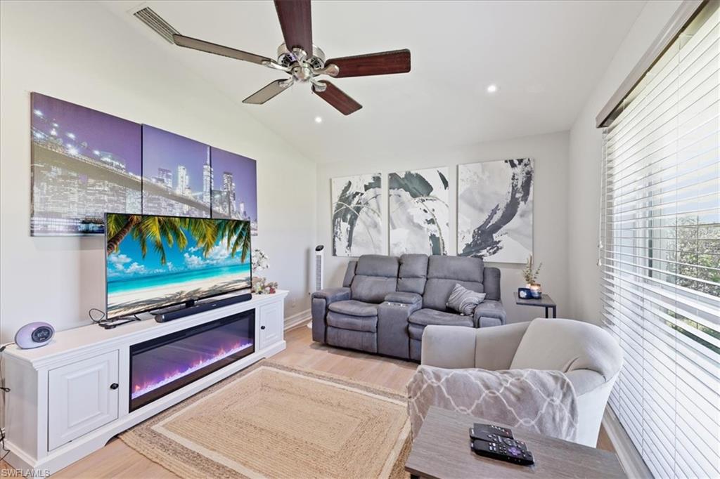 Living area featuring wood-finish flooring, a ceiling fan with integrated lighting, and recessed ceiling lights