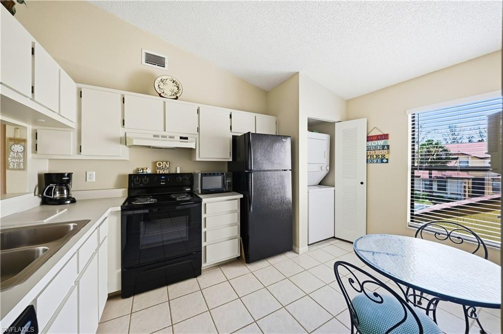 Kitchen featuring white cabinetry, light-colored countertops, and tile flooring