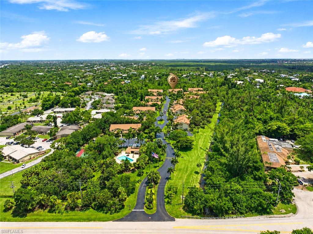 Aerial perspective showcasing a community layout with multiple residential buildings, lush landscaping, and mature trees