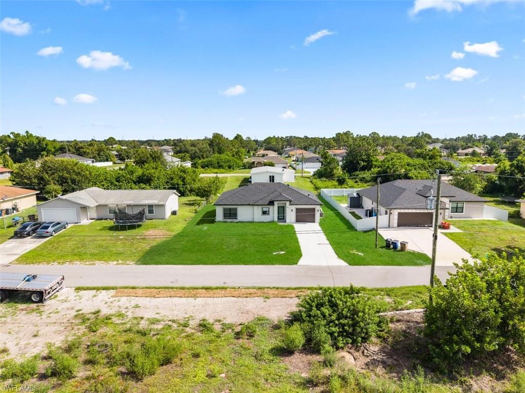 Modern ranch-style residence featuring a dark shingle roof and a concrete driveway