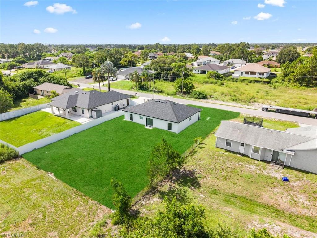 Expansive, freshly sodded lawn with a white privacy fence