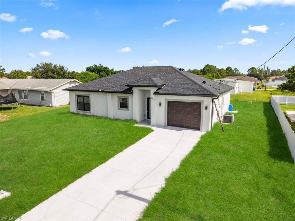 Contemporary single-story residence with a dark shingle roof and light-colored stucco exterior
