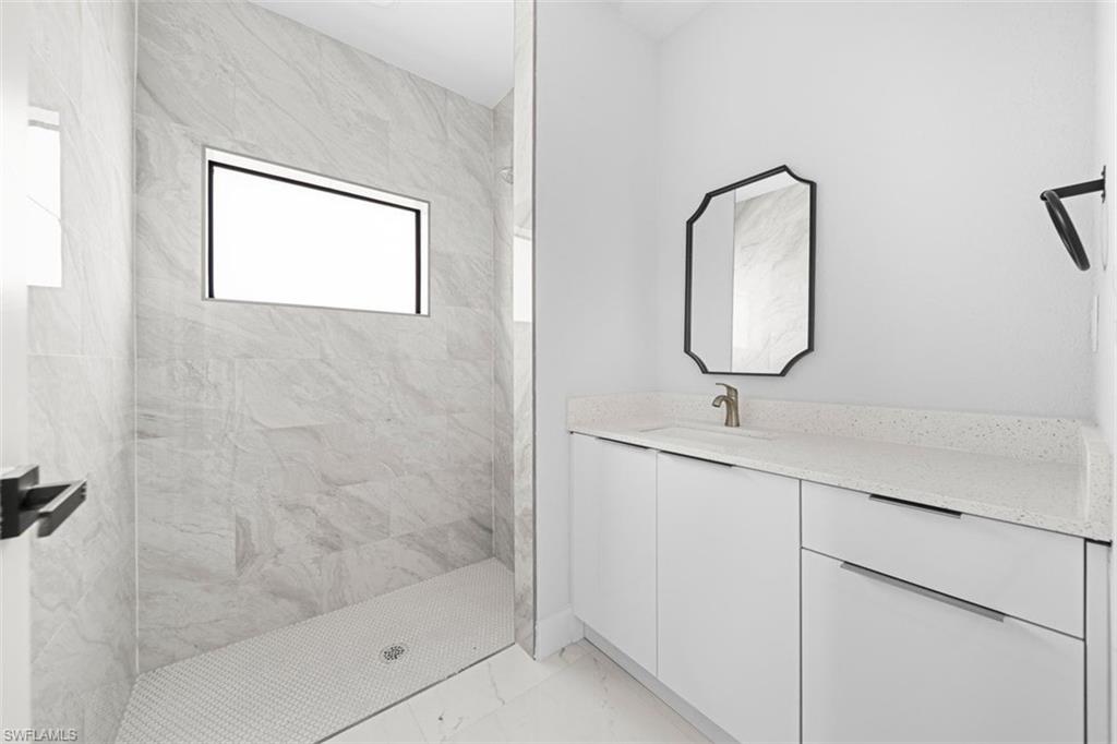 Contemporary bathroom featuring a spacious walk-in shower with large format tile walls and a recessed window