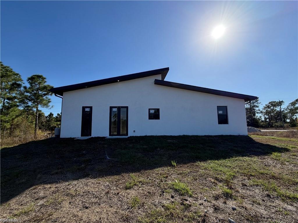 Contemporary exterior featuring a white stucco finish and a dark-toned, angled roofline