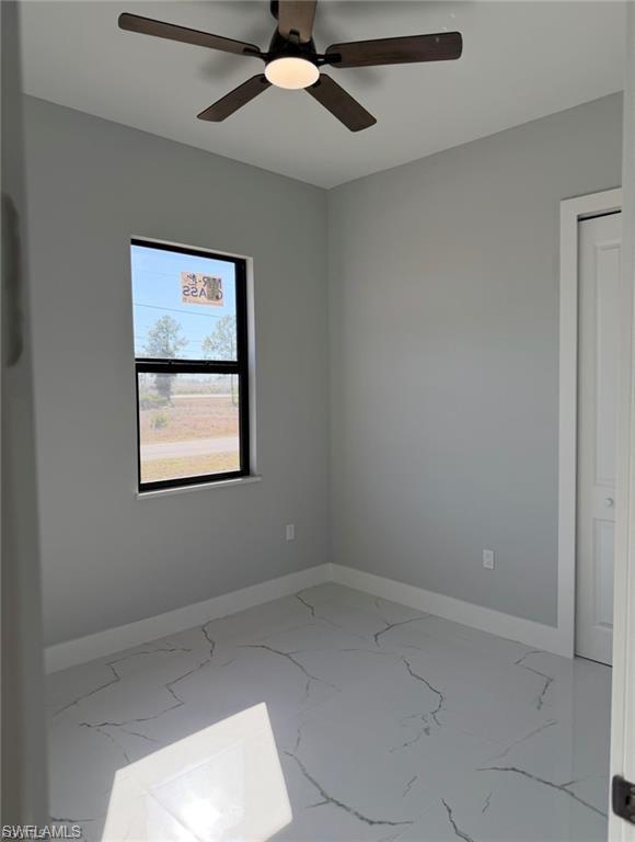 Room featuring a ceiling fan with integrated lighting, a single window with black trim, and light gray wall paint