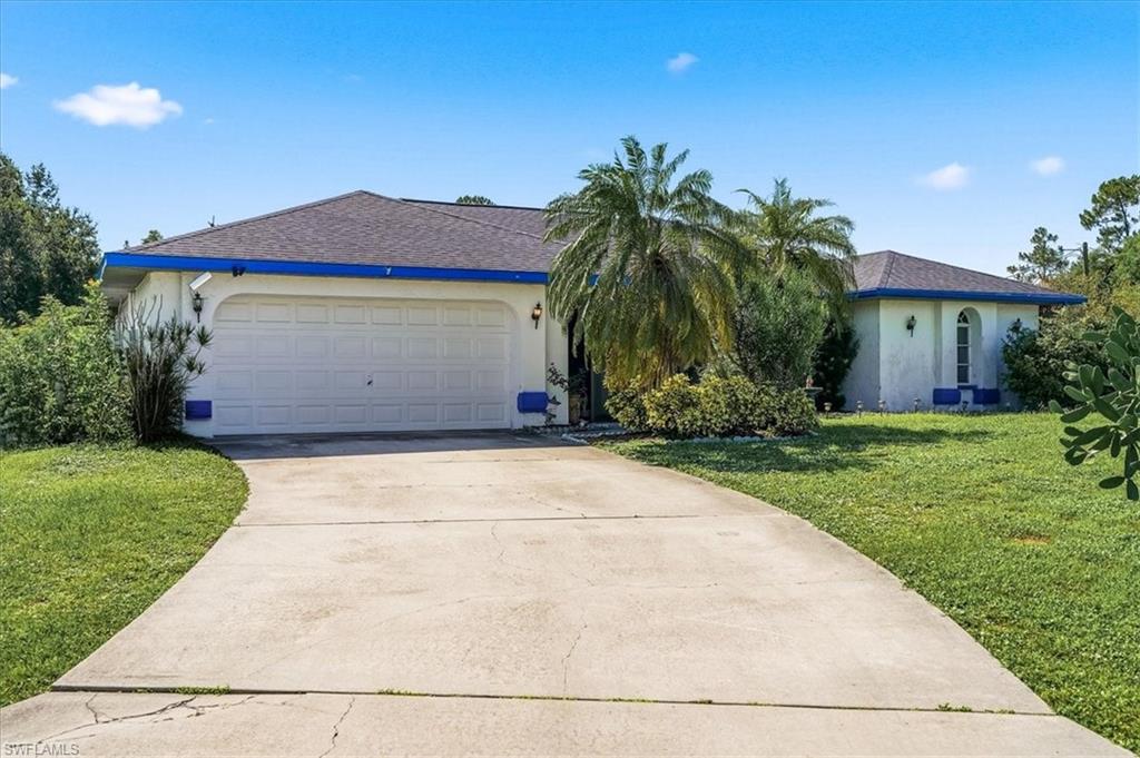 Single-story residence featuring a two-car garage, concrete driveway, and mature landscaping