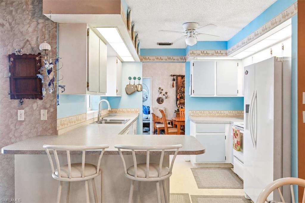 VIRTUALLY STAGED Kitchen featuring white cabinetry, light-toned countertops, and a double basin sink with a gooseneck faucet