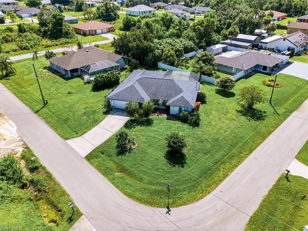 Corner lot property featuring a single-story home with a screened lanai and attached garage