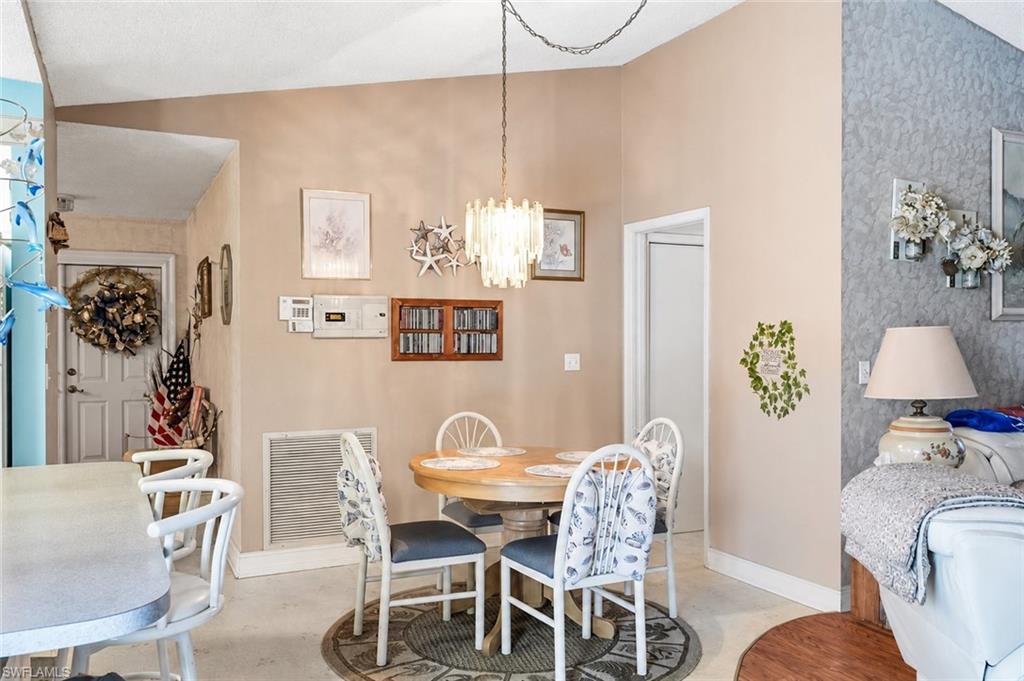 VIRTUALLY STAGED Vaulted ceilings define the dining area, featuring a decorative chandelier and a round table
