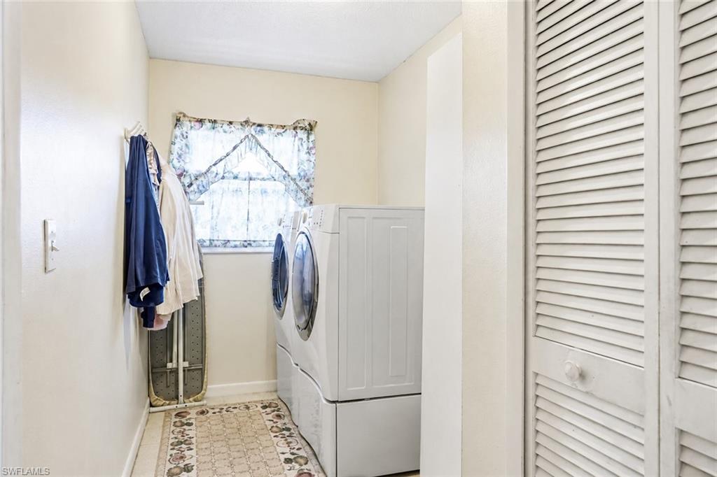 VIRTUALLY STAGED Dedicated laundry area featuring a window, overhead lighting, and louvered bi-fold doors
