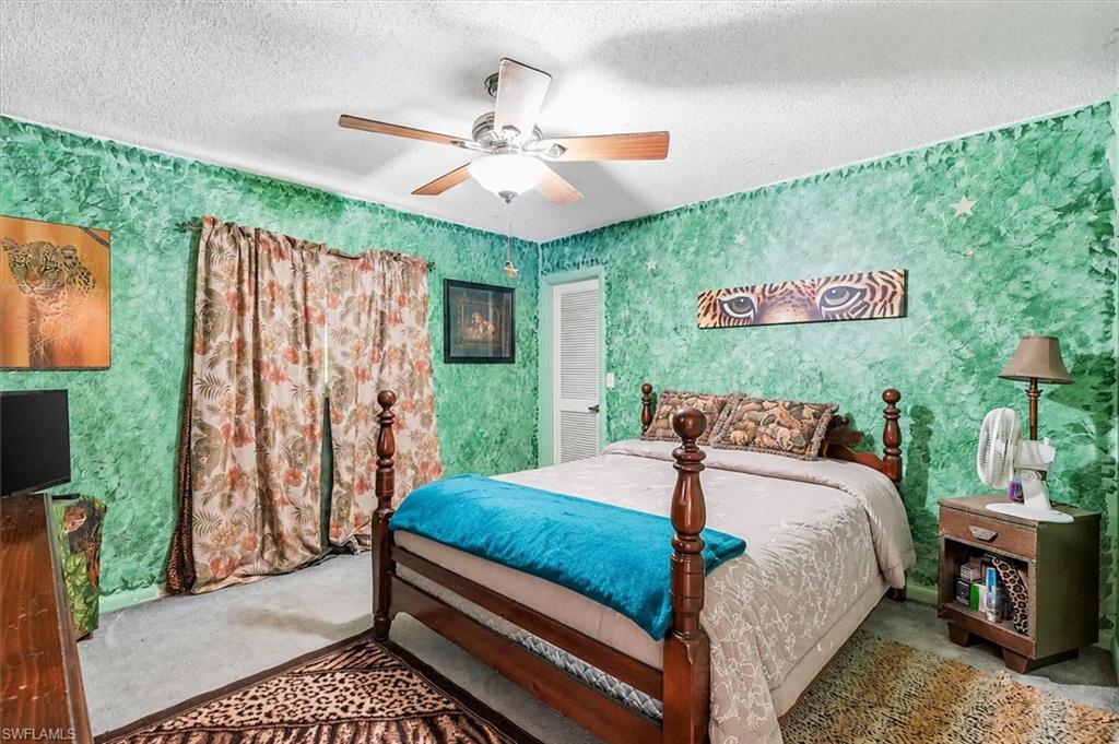 VIRTUALLY STAGED Bedroom featuring green textured walls and light-colored carpeting