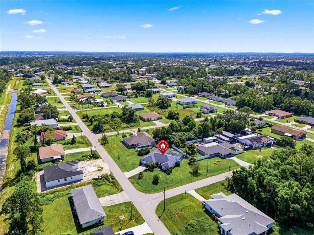 Aerial perspective showcasing a residential neighborhood with numerous single-story homes and verdant landscaping