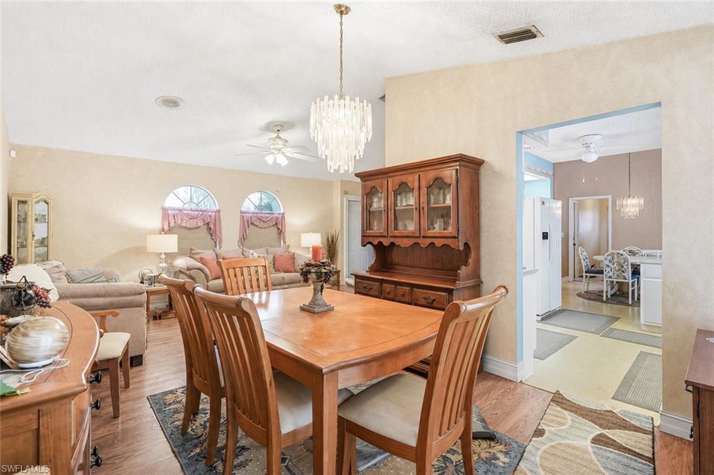 VIRTUALLY STAGED Dining area featuring wood-finish flooring and a contemporary chandelier