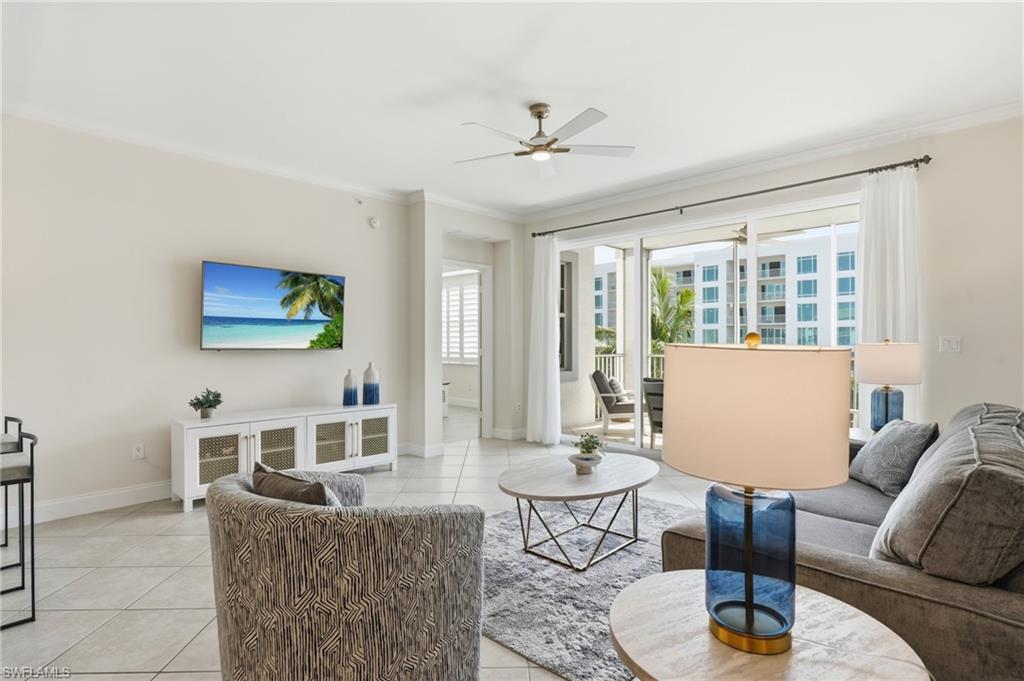 Spacious living area featuring neutral wall tones, tile flooring, and crown molding