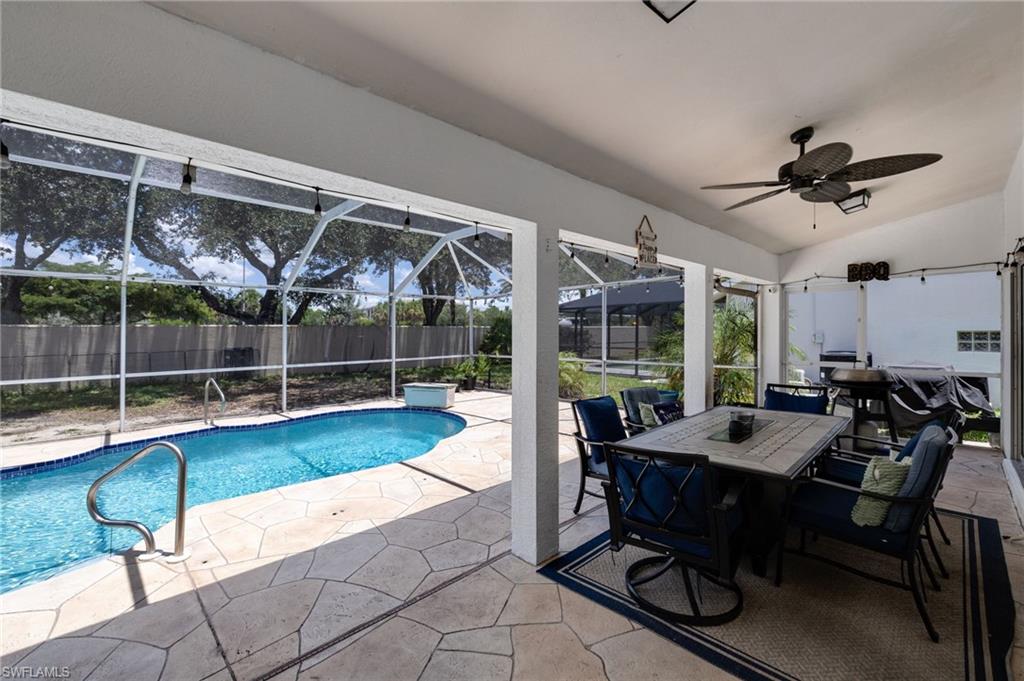 Screened patio featuring a swimming pool with a tiled edge and metal handrails