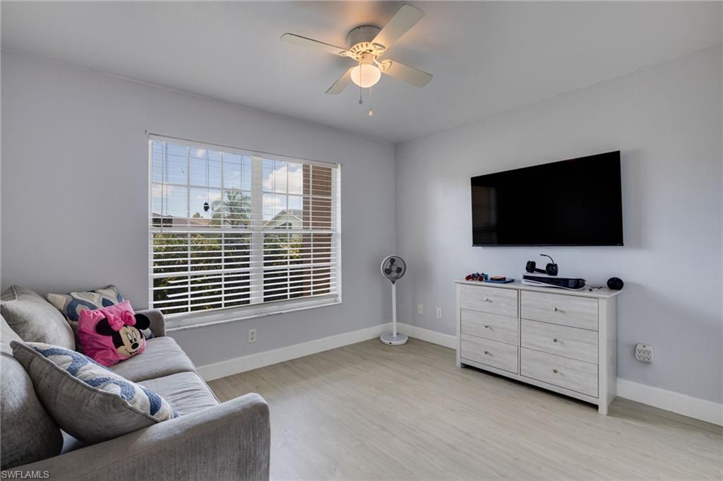 Light grey walls with crown molding and light wood-finish flooring