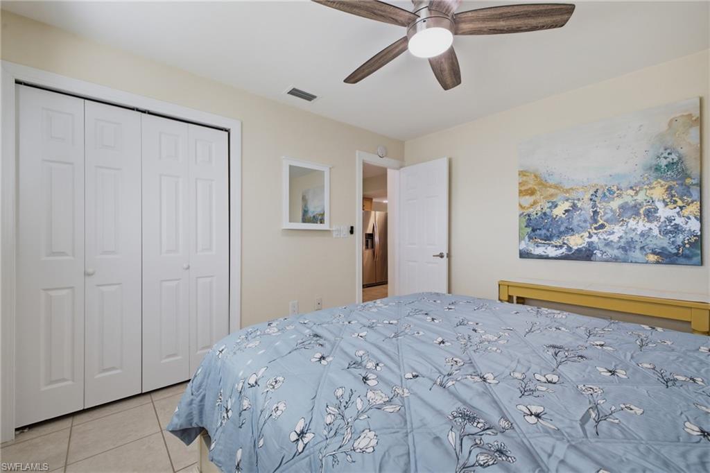 Room with light-toned walls, tile flooring, and a ceiling fan with light fixture