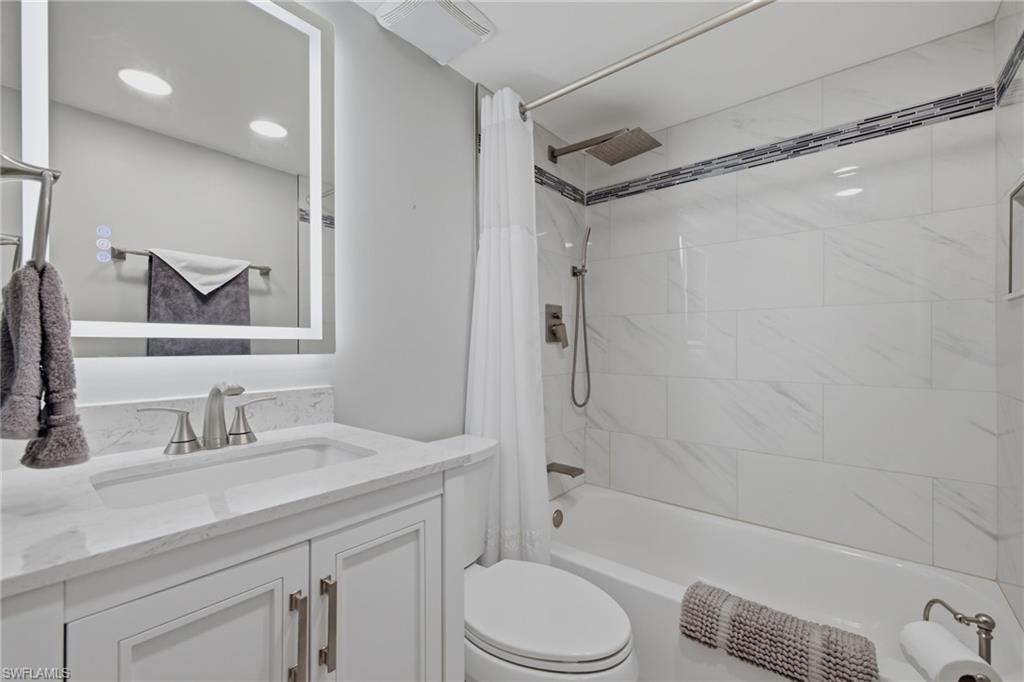 Bathroom featuring a white vanity with brushed nickel hardware and a single basin sink