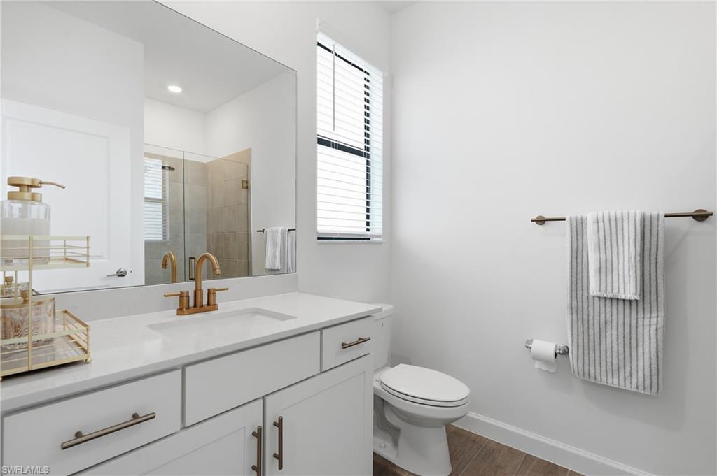 Bathroom featuring a white vanity with gold-finish hardware, a rectangular undermount sink, and a gold-finish faucet