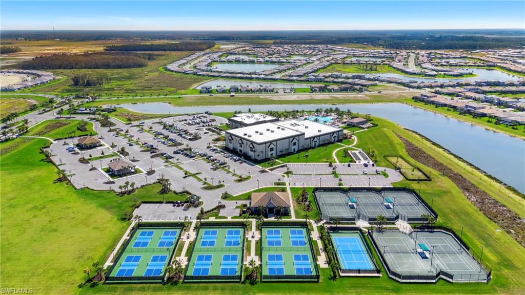 Aerial perspective showcasing multiple recreational courts, a large community building, and extensive parking