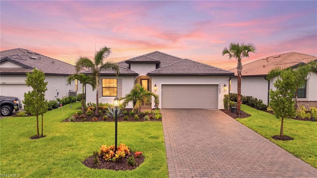 Contemporary single-story residence featuring a tile roof and a paver driveway