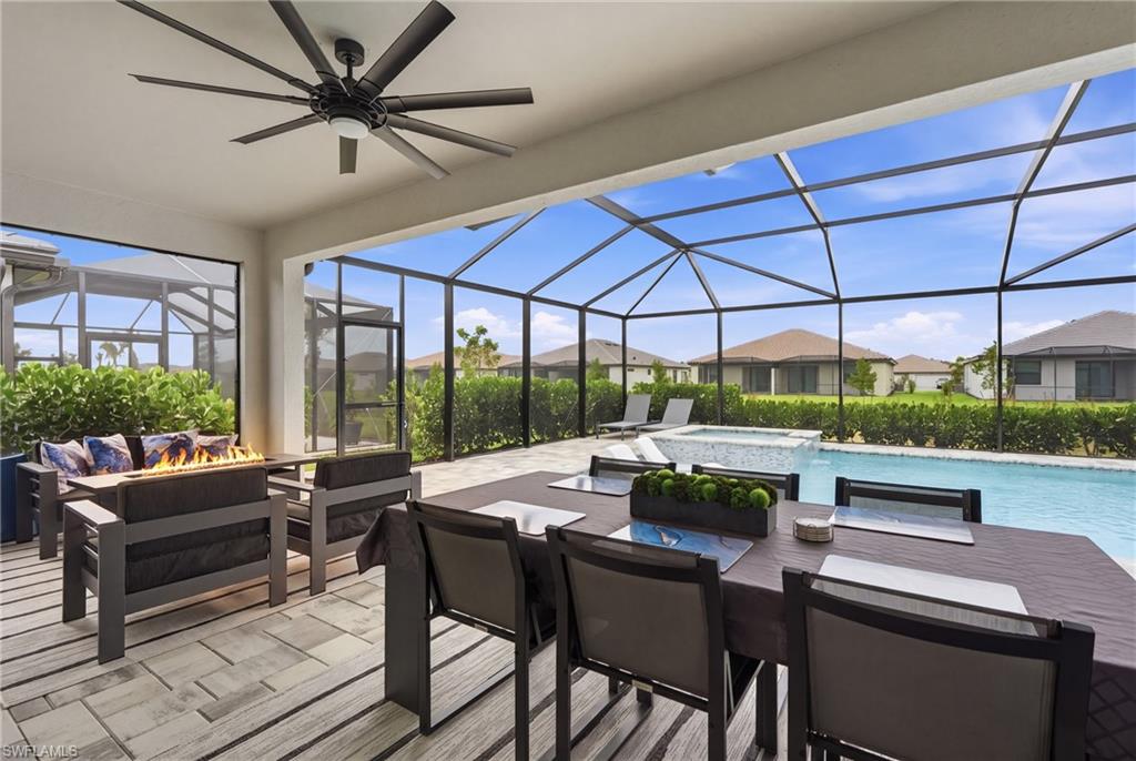 Screened lanai featuring a swimming pool, integrated spa, and an outdoor dining area