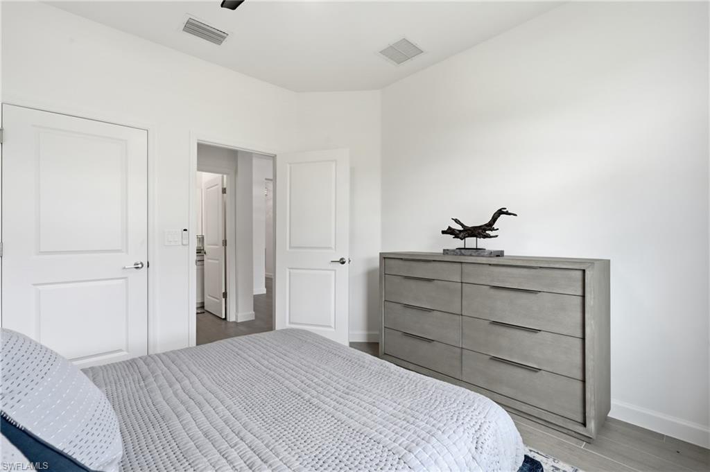Interior room featuring light-toned flooring, white walls, and bright white interior doors with panel detailing
