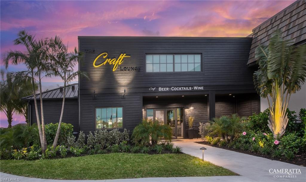 Modern building facade with dark horizontal siding, prominent illuminated signage, and a distinctive cedar shake roofline