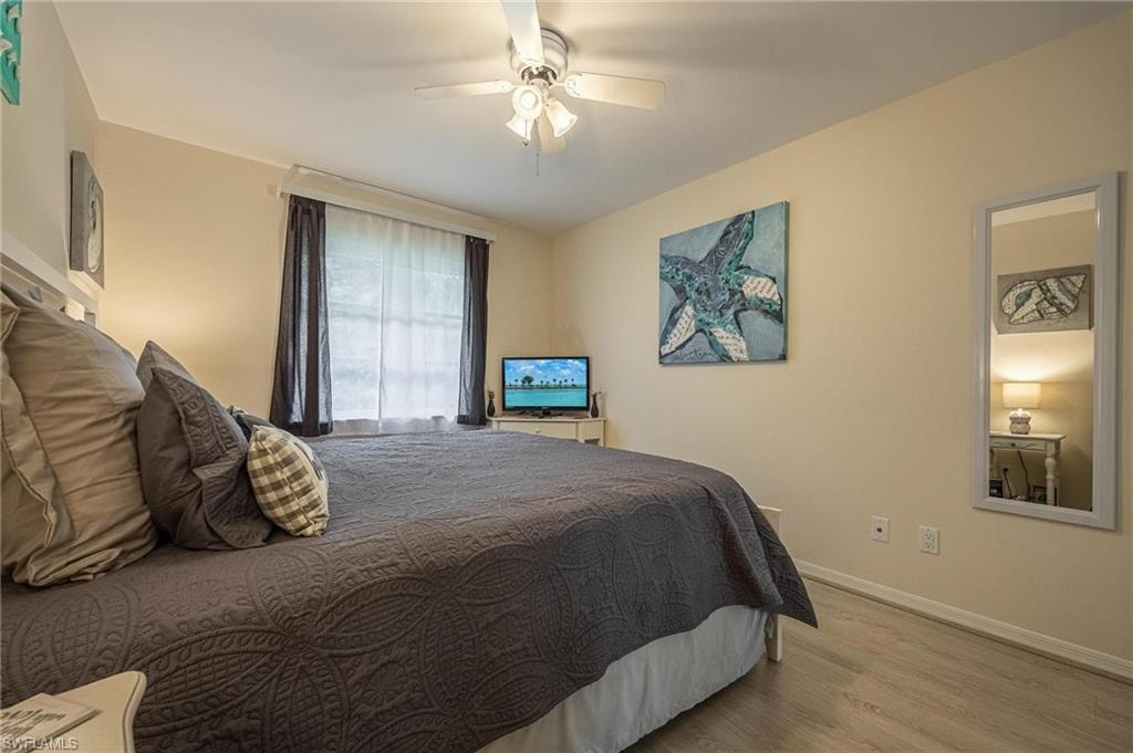 Bedroom featuring wood finished floors, baseboards, and a ceiling fan