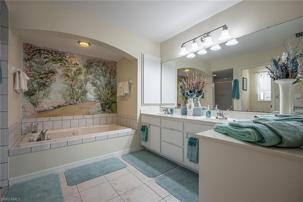 Bathroom with double vanity, a bath, tile patterned floors, and a stall shower
