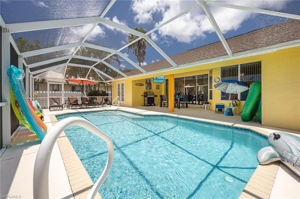 Outdoor pool featuring a patio, grilling area, and glass enclosure