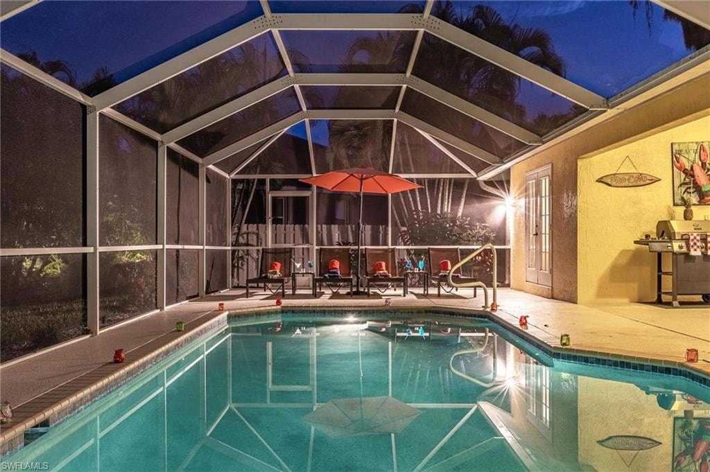 Outdoor pool featuring a patio area, grilling area, and a lanai
