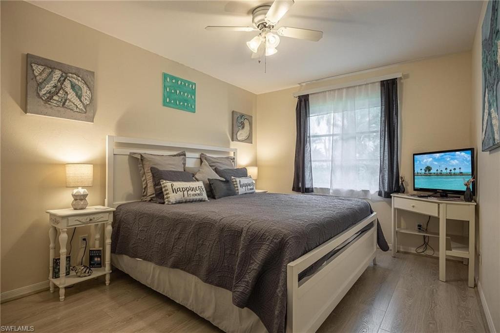 Bedroom with wood finished floors, baseboards, and ceiling fan