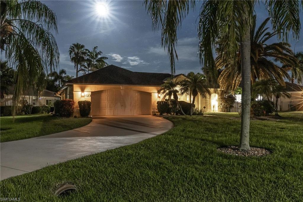 Single story home with concrete driveway, a garage, stucco siding, and a yard